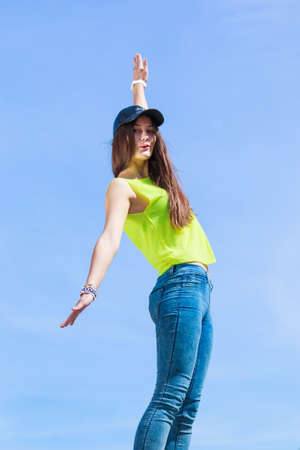 Portrait of pretty casual carefree teenager girl in cap relaxing outdoor. Urban street fashion and freedom concept.の写真素材