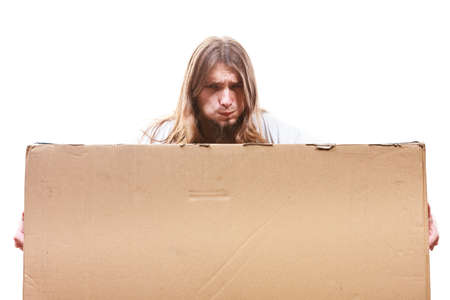 Removal service and delivery concept. Young male guy postal courier holding big very heavy cube package carton.の写真素材