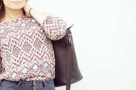 Urban style. Stylish fashionable beauty woman with black bag handbag. Blondie girl model posing...