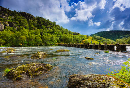 Tourist woman standing on stone slab bridge Terland Klopp in Norway Dalane region.の写真素材