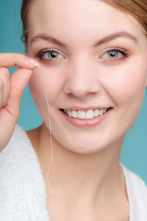Oral hygiene and health care. Smiling woman hold dental floss white healthy teeth.