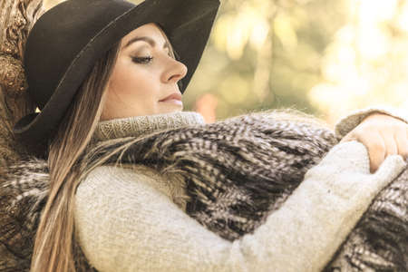 Young beauty woman wearing stylish autumnal clothes relaxing in park. Portrait of fashionable caucasian girl student resting on air.の写真素材
