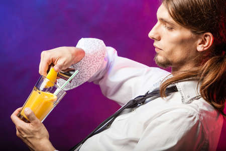 Alcohol liquor party drinking concept. Barman mixing beverages in glass. Male tapster holding drink...