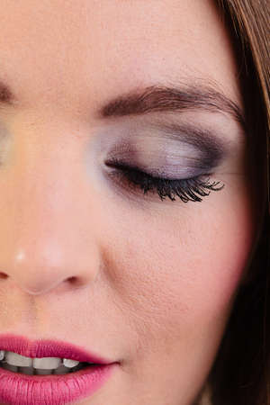 Skincare cosmetics and make up. Young woman with eyeshadows and mascara closeup portrait closed eyesの写真素材