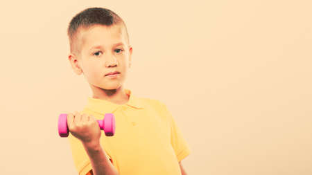 Sports boy making exercise with dumbbell. Care about health and bodyの写真素材