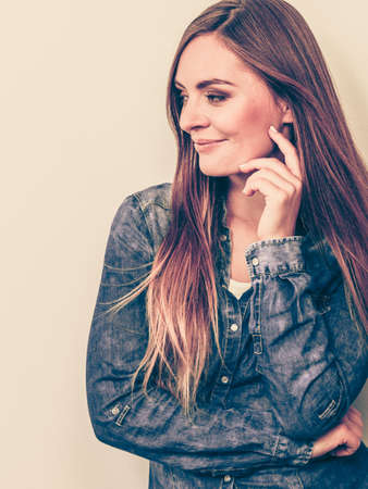 Fashion, beauty, people, jeans concept. Beautiful model posing in the studio. Young lady wearing denim shirt.の写真素材