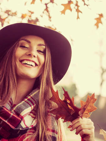 People outdoors concept. Lady with autumnal leaf. Close up picture of leaves in the park.
