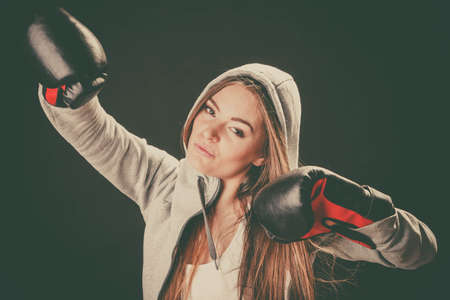 Exercising and fighting with opponent. Sportsmanship and strong body. Energetic woman wear sportswear and boxing gloves. Sport and fitness healthy lifestyle.の写真素材