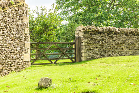 Nature summer landscape. Countryside view and rustic gate in drystone wall in village Bibury England, UK.の写真素材