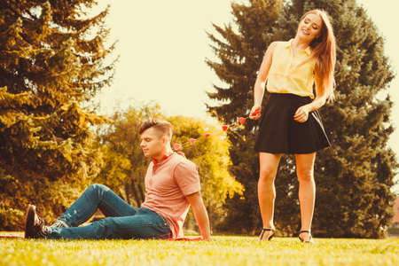 Love romance relationship dating valentines concept. Man held by love on chain. Young male tied to hearts by girl in park.の写真素材