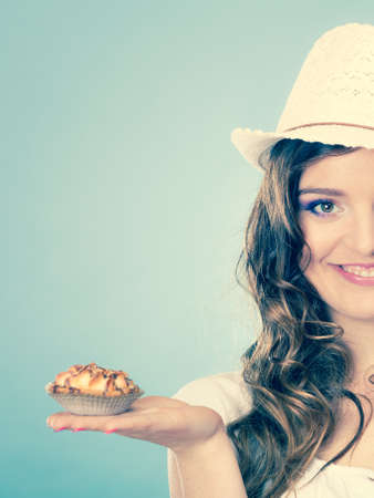 Sweet food sugar make us happy. Attractive woman summer clothing holds cake in hand filtered photoの写真素材
