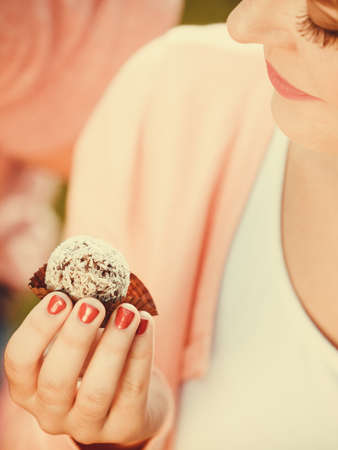 Food and sweets. Appetite and tasty meal dessert. Part body woman with little cookie cupcake. Hand holding small cake.の写真素材