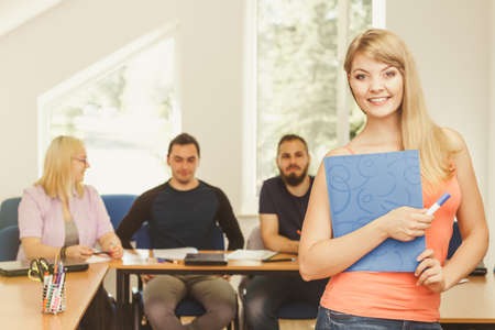 Education, high school, teamwork and people concept - smiling student girl with notebook standing in...