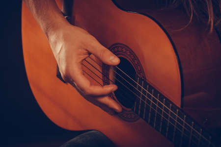 Music hobby people concept. Male hands with guitar. Musician playing the wooden instrument.