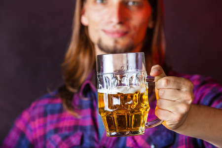 Drinking alcohol liquor relax concept. Young man drinking pint. Male in shirt holding stein with beer.の写真素材
