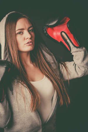 Exercising and fighting with opponent. Sportsmanship and strong body. Energetic woman wear sportswear and boxing gloves. Sport and fitness healthy lifestyle.の写真素材