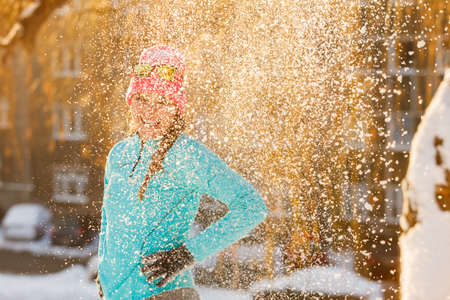 Girl standing in snow. Young woman having fun in winter park. Health nature relax fashion fitness concept.の写真素材