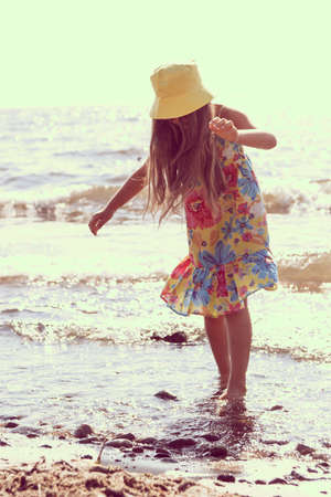 Little girl child kid walking on beach at sea. Summer vacation holidays relax and fun.の写真素材