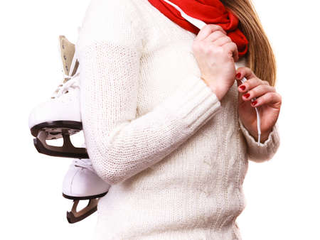 Winter sport equipment concept. Close up picture of ice skates. Woman with white jumper.の写真素材