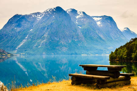 Picnic site wooden table and benches near fjord in Norway, Europe.の写真素材