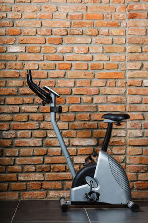Stationary training exercise bicycle in fitness center on wall backgroundの写真素材