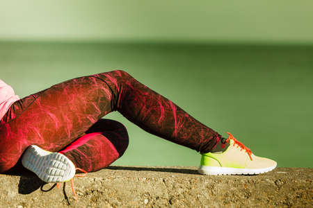 Sports and activities. Part body of training active sporty girl outside. Slim fit legs in vivid color yellow shoes on seaside.の写真素材