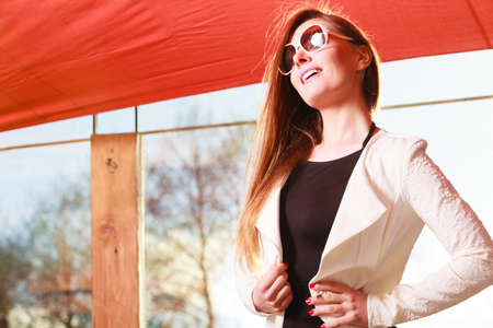 Fashionable girl long haired portrait. Stylish woman enlightened by sunbeams. Attractive elegant female, positive smiling face expressionの写真素材