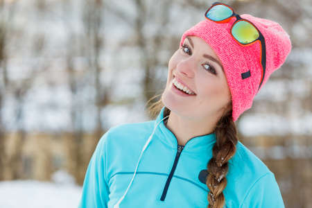 Smiling girl in winter park. Fitness and workout during colder seasons. Health fit nature fashion concept.の写真素材