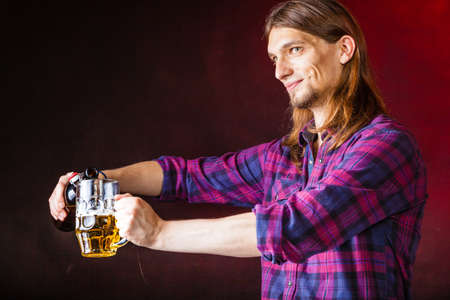 Alcohol liquor drinking relax party concept. Tapster fills stein from bottle. Young male bartender...