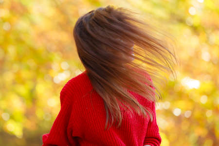 Relaxation and free time. Beauty modern girl in red rest on fresh air in autumn. Lovely attractive woman relax outdoor surrounded by trees and autumnal leaves.の写真素材