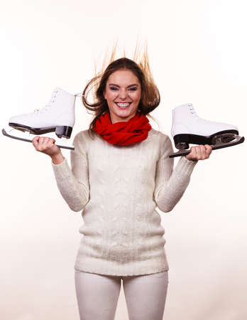 Winter skate sport people concept. Crazy girl with ice skates. Young woman has white outfit and long beutiful hair.の写真素材