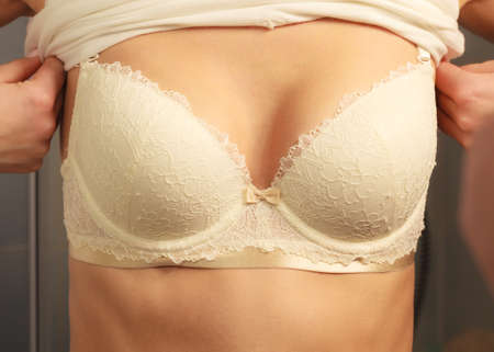 Woman in white bra lingerie taking care of her breasts, closeup female chest in underwearの写真素材