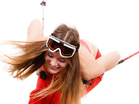 Movement body, sport concept. Young lady sliding down. Woman with long blonde hair with ski poles and goggle on her head.の写真素材