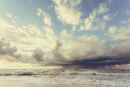 Amazing colorful sunset over evening sea horizon, clouds sky and sandy beach. Tranquil scene. Natural background. Landscape.の写真素材