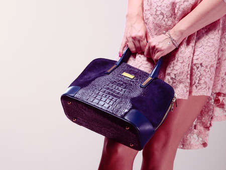Shopping time. Part body of trendy woman wearing lovely lace pink dress. Lady with elegant black bag handbag.の写真素材