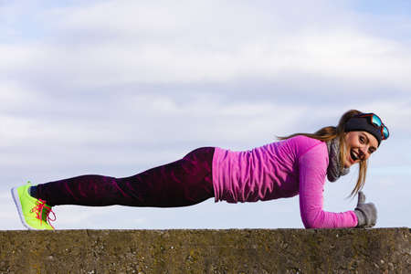 Woman athlete girl training wearing warm sporty clothes outside by seaside in cold weather. Sports...