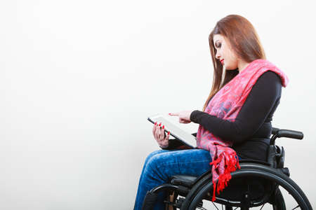 College university and job concept. Mobile technology. Young student worker woman with tablet ebook on wheelchair. Disabled person in real life.の写真素材