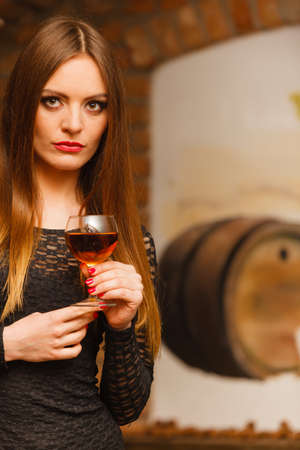 Elegant beauty lady long hair full make up wearing black dress tasting wine in rural cottage...