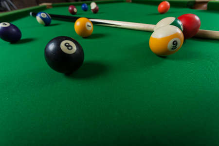 Billiard balls and cue stick on green table. Pool game
