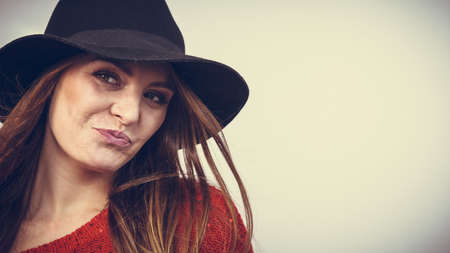 Fashion looks elegance clothing headwear concept. Gorgoeus lady smiling. Young blonde girl wearing elegant hat cheering expressing happinessの写真素材