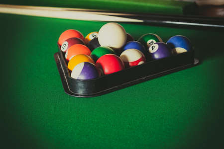 Billiard balls and cue stick on green table. Pool game