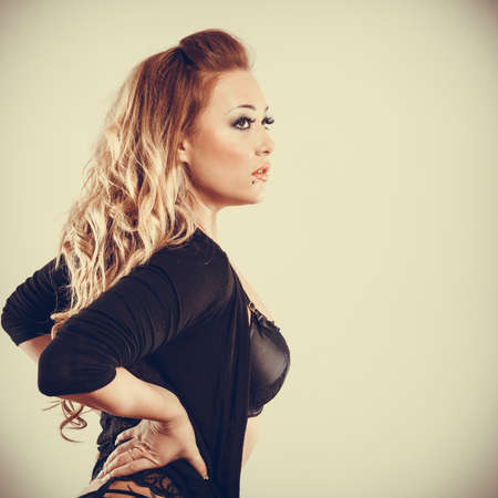 Beauty of female body. Portrait of sexy young blonde woman in black. Long haired seductive girl wearing lingerie.の写真素材
