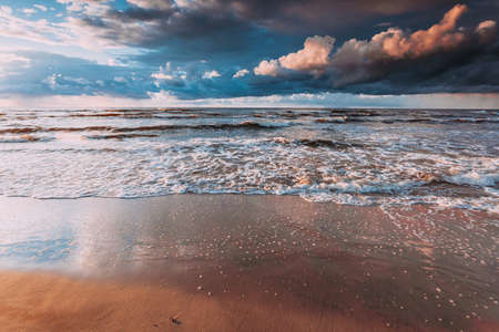 Amazing colorful sunset over evening sea horizon, clouds sky and sandy beach. Tranquil scene. Natural background. Landscape.の写真素材