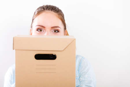 Woman moving in carrying cartons boxes. Young girl arranging interior and unpacking at new apartment house home.の写真素材