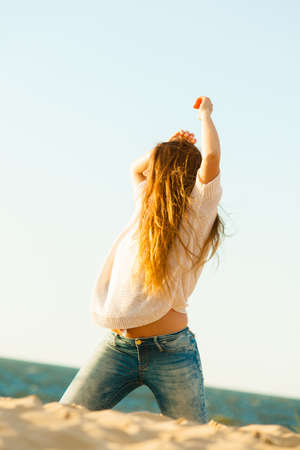 Joy and carefree. Gorgeous long haired woman having fun on beach. Young joyful attractive girl feels freedom. Summer time.の写真素材