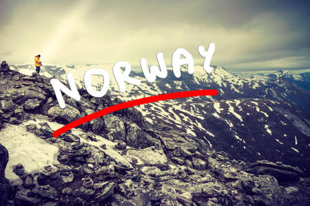 Tourism vacation and travel. Male tourist taking photo with camera, enjoying mountains landscape from Dalsnibba viewpoint, Norway Scandinavia.の写真素材
