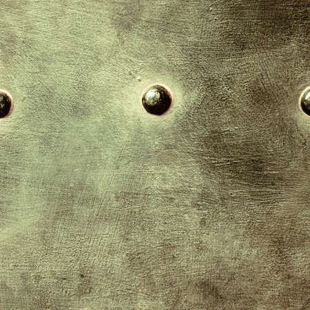 grunge metal plate or armour texture with rivets as backgroundの写真素材