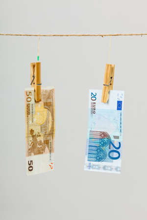 Banknotes cash money hang on laundry line on gray grey background.の写真素材