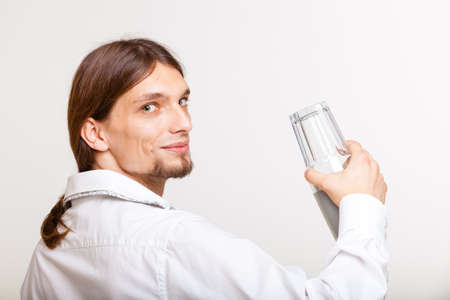 Alcohol liquor drinking relax party concept. Male barman makes cocktail. Young bartender holding glasses making drink.の写真素材