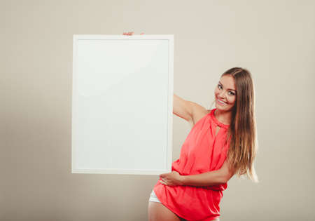 Cute attractive young woman girl in red shirt in studio with blank empty white copy space banner. Summer female fashion vogue and advertisement.の写真素材
